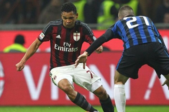 Striker AC Milan, Carlos Bacca, mendapat tantangan dari pemain Inter Milan, Davide Santon, dalam duel Serie A di Stadio Giuseppe Meazza pada 31 January 2016.