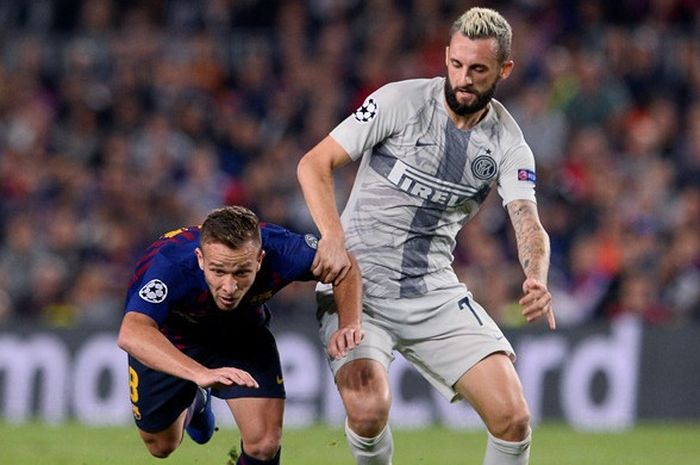 Gelandang FC Barcelona, Arthur (kiri), berduel dengan gelandang Inter Milan, Marcelo Brozovic, dalam laga Grup B Liga Champions di Stadion Camp Nou, Barcelona, Spanyol pada 24 Oktober 2018.