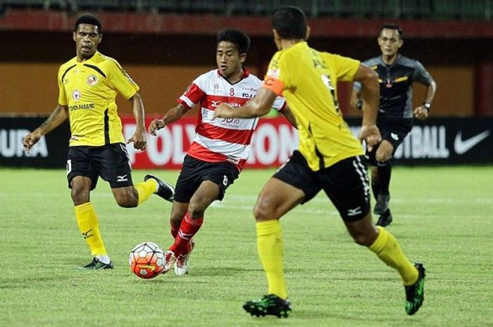 Penyerang Madura United, Bayu Gatra, menggiring bola dibayangi dua pemain Semen Padang, dalam laga perdana Grup E Piala Presiden 2017 di Stadion Gelora Ratu Pamelingan Pamekasan, Jawa Timur (08/02/2017).