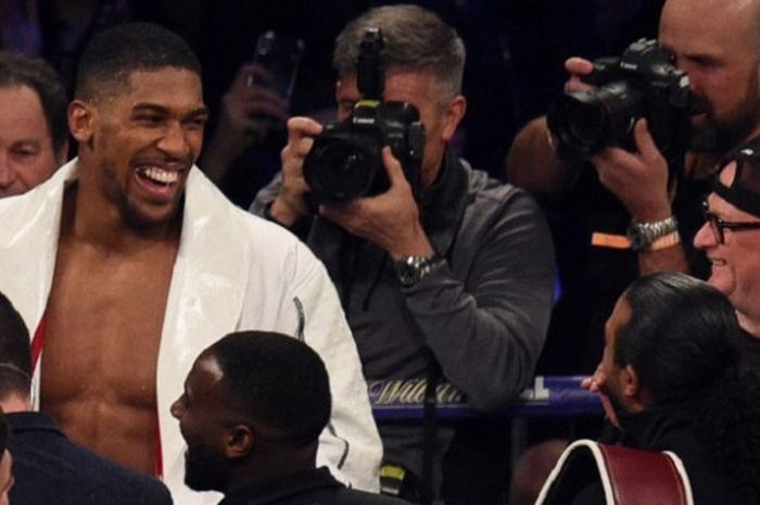 Petinju kelas berat Inggris, Anthony Joshua, tersenyum seusai mengalahkan Joseph Parker (Selandia Baru) pada laga di  Principality Stadium, Cardiff, Wales, Sabtu (31/3/2018).