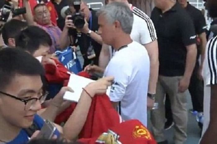 Jose Mourinho disambut fans yang meminta tanda tangan di Stadion Shanghai, Kamis (21/7/2016). 