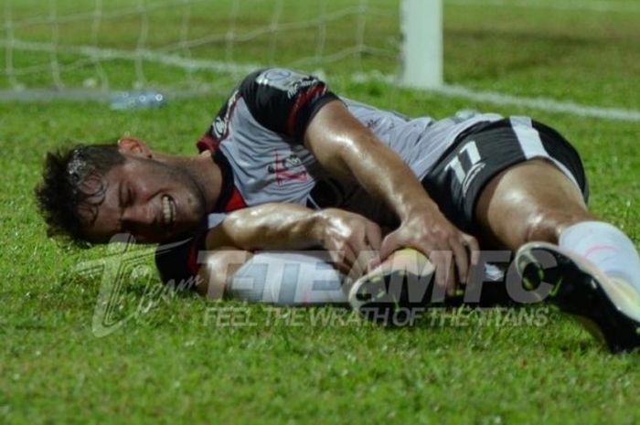 Striker asal Brasil, Patrick Cruz kesakitan saat membela timnya, T-Team FC yang menjamu Felda United pada laga Liga Super Malaysia 2016 di Stadion Sultan Ismail Nasiruddin Shah, Kuala Terengganu, 10 September 2016.  