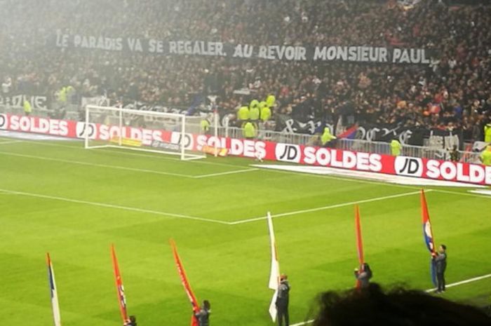 Suporter Lyon membentangkan spanduk bertuliskan 'Surga akan berpesta, Selamat tinggal Mr. Paul' pada laga kontra PSG di Stadion Groupama, Minggu (21/1/2018).