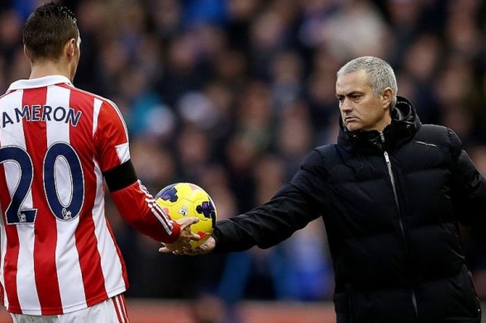 Jose Mourinho (kanan) menyerahkan bola kepada pemain Stoke City, Geoff Cameron, pada duel Premier League di Stadion Britannia, 7 Desember 2013.