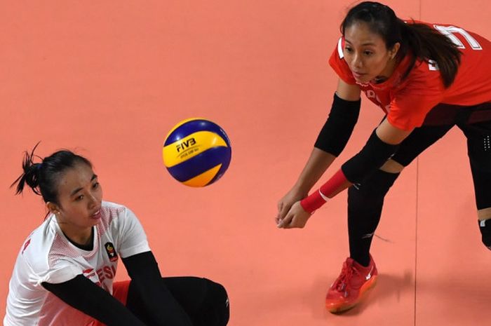 Aksi pemain voli timnas Indonesia, Berllian Marsheilla dan Amalia Fajrina Nabila, menghalau bola pada laga melawan Hong Kong di Stadion Volley Gelora Bung Karno, Selasa (21/8/2018).   