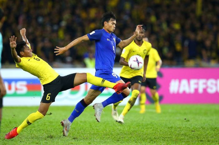 Pemain timnas Malaysia, Syazwan Andik (6) saat mencoba menghentikan laju penyerang Thailand, Supachai Jaided pada semifinal pertama Piala AFF 2018 di Stadion Nasional Bukit Jalil, Kuala Lumpur, 1 Desember 2018. 