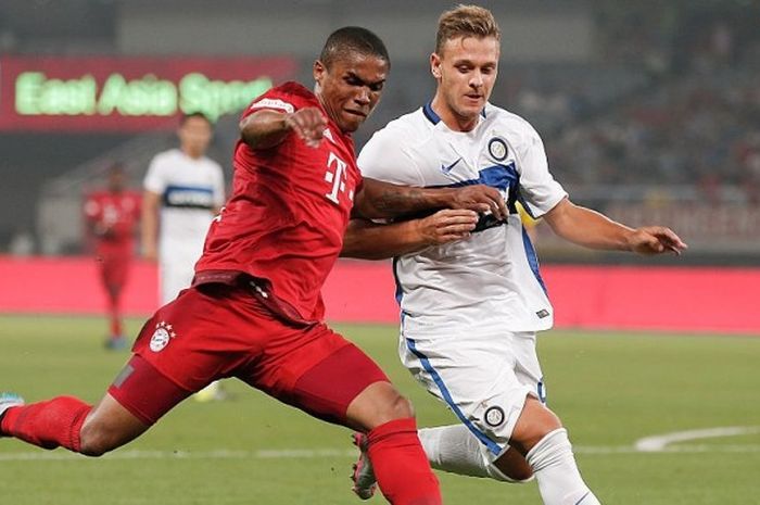 Douglas Costa (kiri) saat berusaha melewati hadangan pemain Inter Milan, Federico Dimarco di pertandingan persahabatan Audi Cup di Shanghai Stadium pada 21 Juli 2015. 