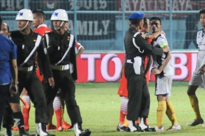 Penyerang Sriwijaya FC, Ferdinand Sinaga, ditenangkan oleh Polisi Militer seusai laga melawan Persija, Rabu (25/11/2015)