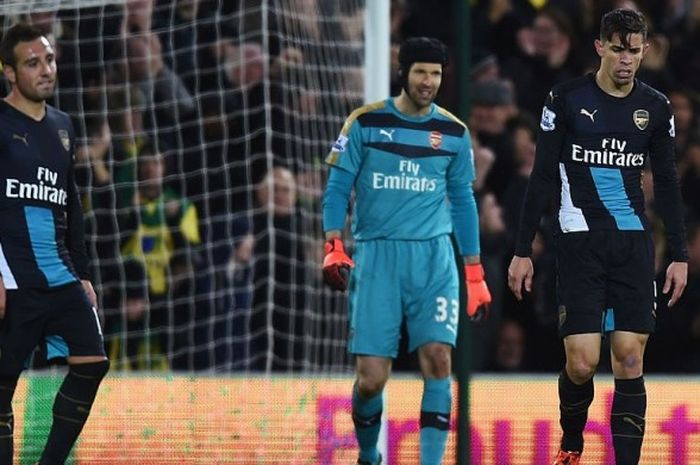 Santi Cazorla, Petr Cech, dan Gabriel Paulista tertunduk lesu setelah Arsenal tidak sanggup memetik kemenangan atas Norwich City di Carrow Road, Minggu (29/11/2015) atau Senin dini hari WIB. 