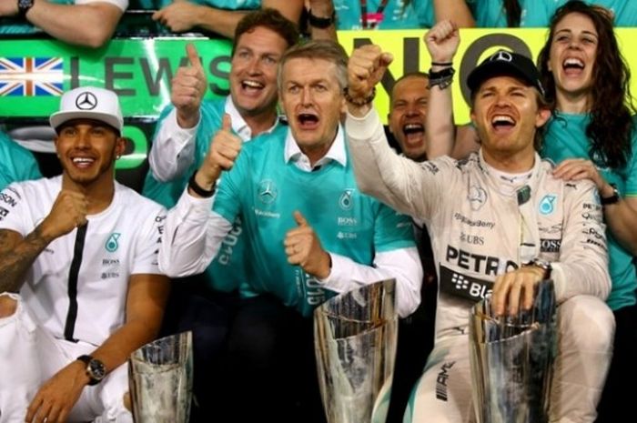 Nico Rosberg (kanan), merayakan kemenangan di GP Abu Dhabi (29/11/2015) bersama Lewis Hamilton (kiri) dan kru tim Mercedes.