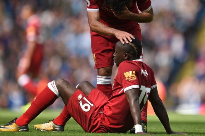 Penyerang Liverpool, Sadio Mane (terduduk), mendapat penghiburan dari Mohamed Salah setelah menerima kartu merah dalam laga Liga Inggris di Stadion Etihad, Manchester, Inggris, pada Sabtu (9/9/2017).