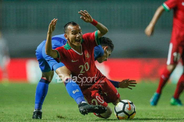  Pemain timnas U-23 Indonesia, Riko Simanjuntak, diadang pemain timnas U-23 Thailand, di Stadion Pakansari, Kabupaten Bogor, Minggu (3/6/2018). 