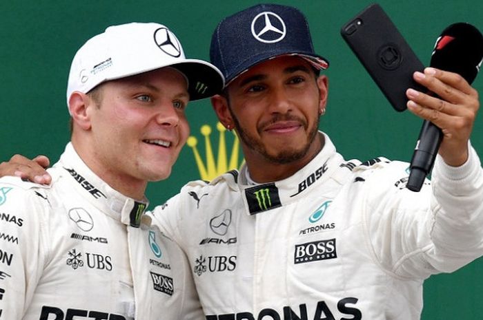 Dua pebalap tim Mercedes, Valtteri Bottas (kiri) dan Lewis Hamilton, melakukan swafoto seusai balapan GP Inggris di Sirkuit Silverstone, 16 Juli 2017.
