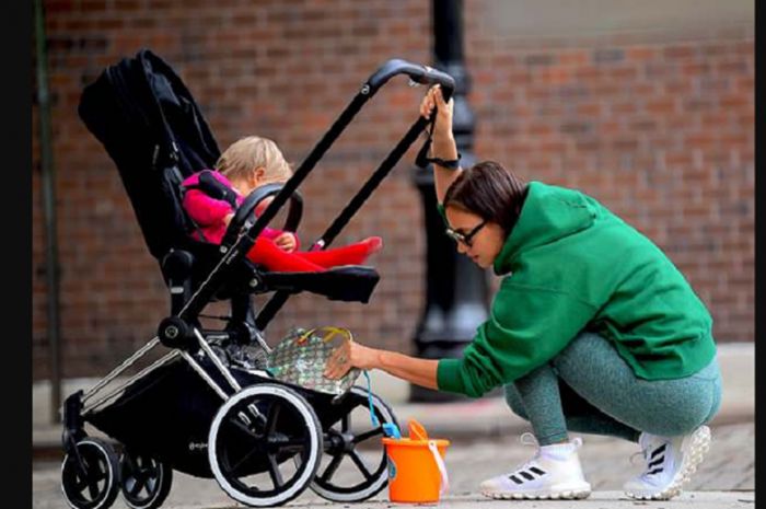 Irina Shayk mengambil minum untuk anaknya saat jalan-jalan dikawasan Kota New York bersama sang putri pada Kamis,(17/5/2018)