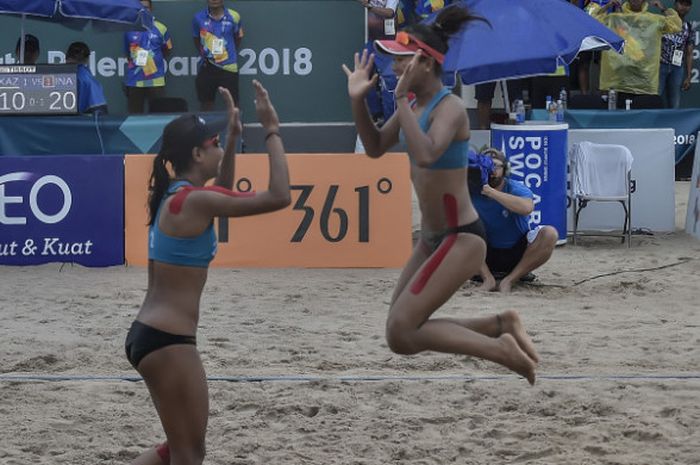 Pevoli pantai putri Indonesia Putu Dini Jasita Utami (kanan) dan Dhita Juliana (kiri) melakukan selebrasi seusai mengalahkan pevoli Kazakhstan pada final voli pantai putri Asian Games 2018 di arena Jakabaring Sport City, Palembang, Sumsel, Senin (27/8/2018).