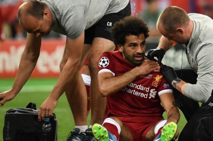   Striker Liverpool, Mohamed Salah, mendapatkan perawatan akibat cedera dalam laga final Liga Champions kontra Real Madrid di Stadion NSC Olimpiyskiy, Kiev, Ukraina pada 26 Mei 2018.  