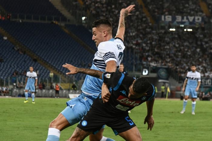 Gelandang Lazio, Sergej Milinkovic-Savic (kiri), berduel dengan gelandang Napoli, Allan, dalam laga Liga Italia di Stadion Olimpico, Roma pada 18 Agustus 2018.