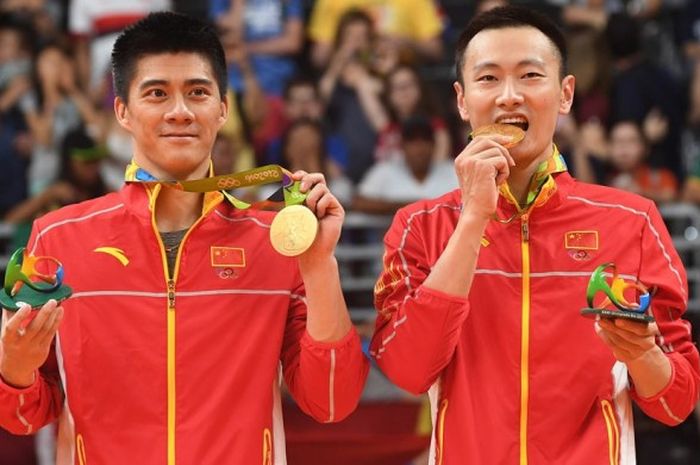 Pasangan ganda putra China, Fu Haifeng/Zhang Nan, berfoto dengan medali emas Olimpiade Rio 2016 yang mereka menangi setelah mengalahkan Goh V Shem/Tan Wee Kiong (Malaysia), 16-21, 21-11, 23-21, di Riocentro Pavilion 4, Rio de Janeiro, Brasil, Jumat (19/8/2016).