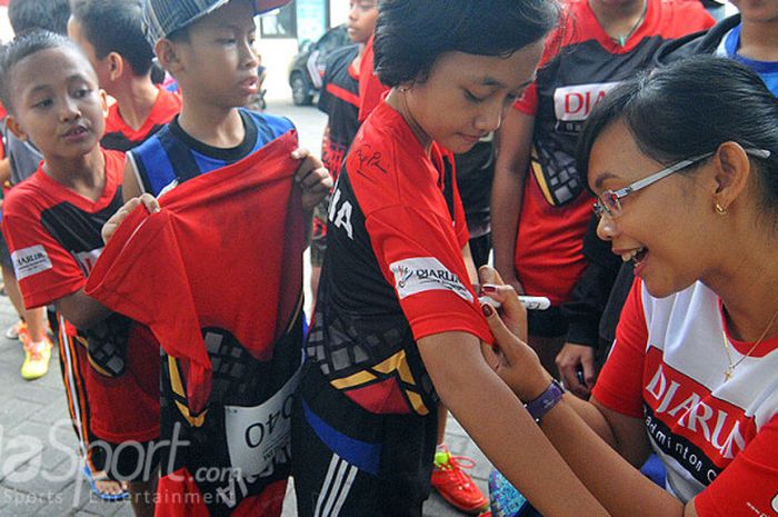 Mantan pebulu tangkis Indonesia sekaligus tim pemandu bakat, Maria Kristin membubuhkan tanda tangan di kaos peserta Audisi Umum Djarum Beasiswa Bulutangkis 2017 di GOR Sudirman, Surabaya Minggu (6/8/2017).