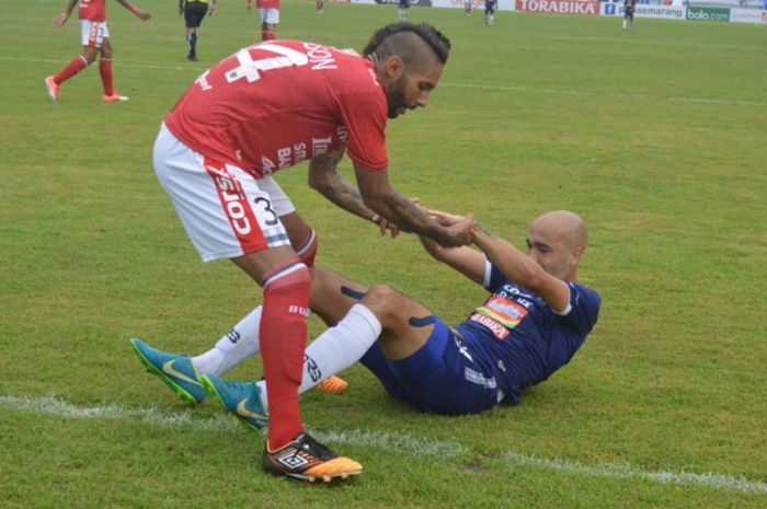 Pemain Bali United, Demerson Bruno Costa (kiri), saat berusaha memberikan pertolongan kepada pemain PSIS Semarang, Bruno Silva (kanan) pada laga Liga 1 2018, Minggu (1/4/2018),