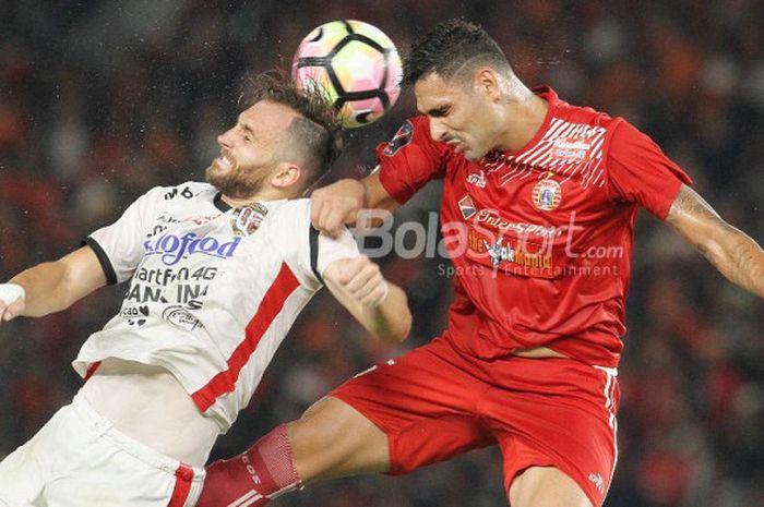  Striker Bali United, Ilija Spasojevic (kiri), berduel dengan bek Persija, Jaimerson da Silva (kanan), pada laga final Piala Presiden 2018 di Stadion Utama GBK pada Sabtu (17/2/2018).  