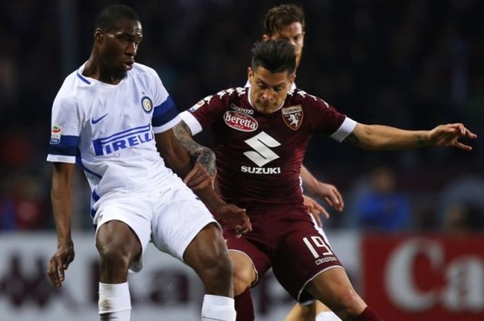 Pemain Inter Milan (kanan) tengah berebut bola melawan penyerang Torino, Juan Iturbe pada pertandingan yang berlangsung di Stadion Grande Torino, Sabtu (18/3/2017) waktu setempat.