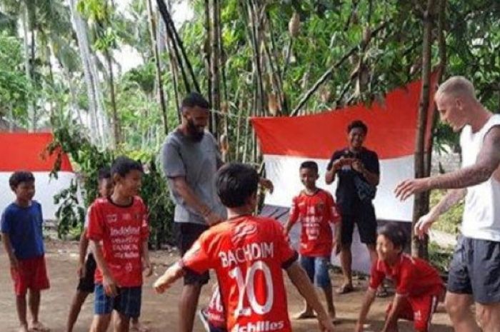 Mantan pemain Bali United, Sylvano Comvalius dan Nick Van der Velden sedang bermain sepak bola bersama anak-anak.