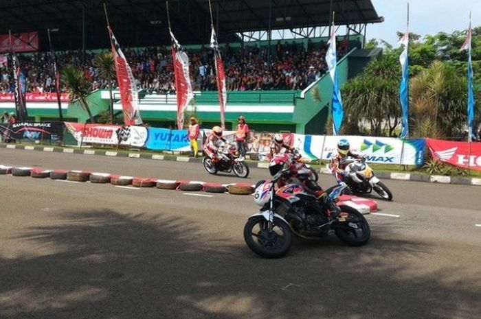 Aksi para pebalap yang ambil bagian dalam kelas Sport 150cc Tune Up Terbuka pada Honda Dream Cup Serie Ke-2 di Lapangan Brigif 15 Kujang II, Cimahi, Jawa Barat, pada Minggu (25/7/2016).