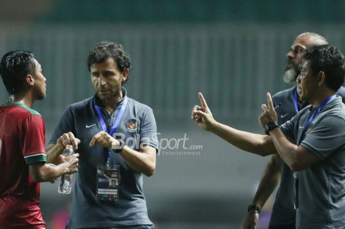        Pelatih Timnas U-23 Indonesia, Luis Milla (tengah), beserta asisten pelatih Bima Sakti (kanan) memberikan instruksi kepada Muhammad Hargianto pada laga PSSI Anniversary Cup 2018 kontra Bahrain di Stadion Pakansari, Bogor, Jumat (27/4/2018)       