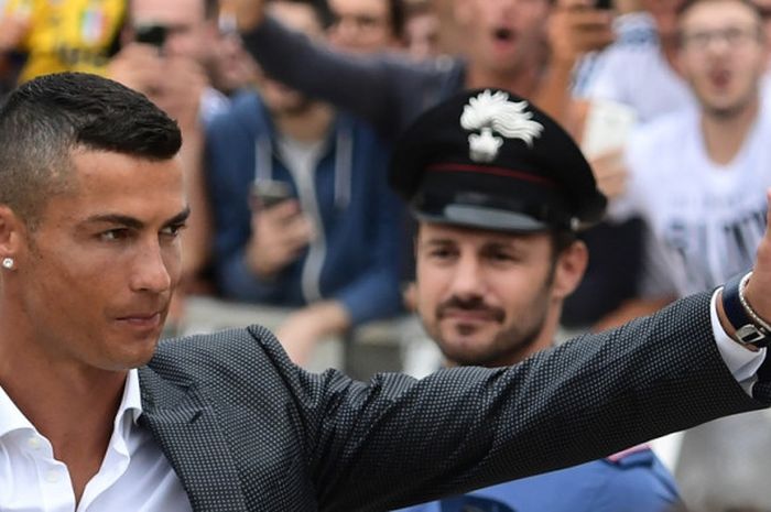         Pemain baru Juventus, Cristiano Ronaldo, melambaikan tangan kepada para suporter saat tiba untuk melakukan tes medis di markas klub di Stadion Allianz, Turin, Senin (16/7/2018).        