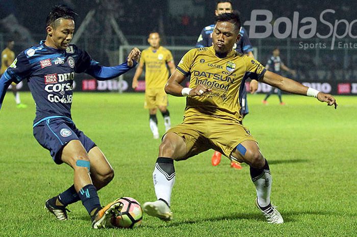 Gelandang Arema FC, Dendi Santoso (kiri), berebut bola dengan gelandang Persib Bandung, Tony Sucipto, dalam laga pekan ke-19 Liga 1 di Stadion Kanjuruhan Malang, Jawa Timur, Sabtu (12/08/2017) malam.