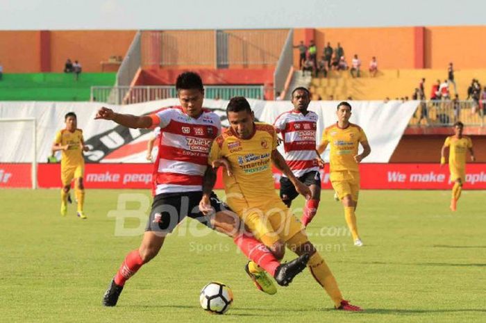 Bek Madura United, Fachruddin Aryanto, berduel dengan penyerang Sriwijaya FC, Beto Goncalves, dalam laga Liga 1 2018 yang bergulir di Stadion Pamekasan, Sabtu (7/4/2018).