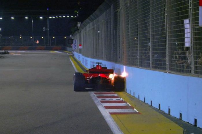 Pebalap Ferrari Sebastian Vettel menyenggol dinding pembatas saat keluar dari tikungan 21 Sirkuit Jalan Raya Marina Bay saat latihan bebas kedua F1 GP Singapura, Jumat (14/9/2018).