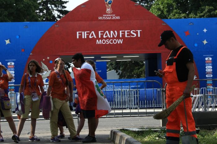 Seorang fan Peru berbincang dengan para volunteer di depan pintu fan fest Moskow yang tutup di kawasan Sparrow Hills, Moskow, pada Sabtu (30/6/2018). 
