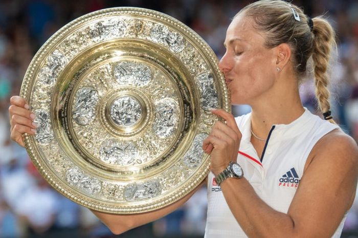 Angelique Kerber saat mencium trofi yang baru saja didapatkannya usai memenangi partai final tunggal putri Wimbledon 2018, Sabtu (14/7/2018).