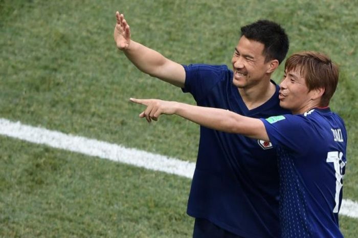 Pemain timnas Jepang, Shinji Okazaki (kiri) dan Takashi Inui merayakan kelolosan mereka ke babak 16 besar Piala Dunia 2018 setelah partai terakhir Grup H kontra Polandia di Volgograd Arena, 28 Juni 2018.