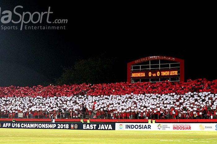   Pendukung timnas U-16 Indonesia membuat koreografi pada laga keempat Grup A Piala AFF U-16 2018 antara timnas U-16 Indonesia melawan Timor Leste di Stadion Gelora Delta Sidoarjo, Jawa Timur, Sabtu (04/08/2018) malam.  