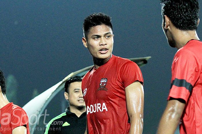   Pemain belakang Madura United, Fachruddin Aryanto (tengah), berbicara dengan rekan setimnya usai l