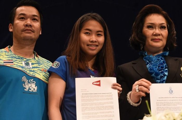 Pebulu tangkis tunggal putri Thailand, Ratchanok Intanon (tengah), menunjukkan surat dari BWF yang menyatakan dirinya bebas dari tuduhan doping pada konferensi pers di Bangkok, Thailand, Senin (18/7/2016).