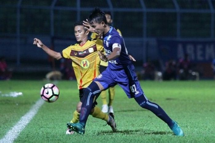 Kapten Arema, Ahmad Alfarizi, membawa bola dengan dibayangi pemain Barito Putera saat kedua tim bertemu di Stadion Kanjuruhan, Jumat (5/5/2017). 