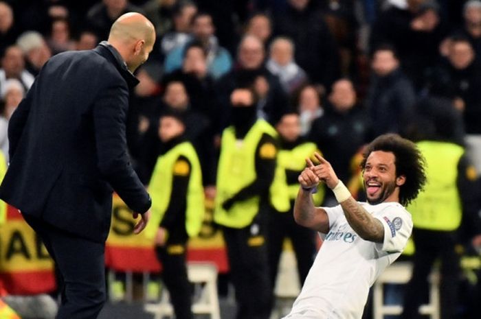 Bek kiri Real Madrid, Marcelo (kanan), merayakan golnya bersama pelatih Zinedine Zidane dalam laga leg pertama babak 16 besar Liga Champions kontra Paris Saint-Germain di Stadion Santiago Bernabeu, Madrid, Spanyol, pada 14 Februari 2018.