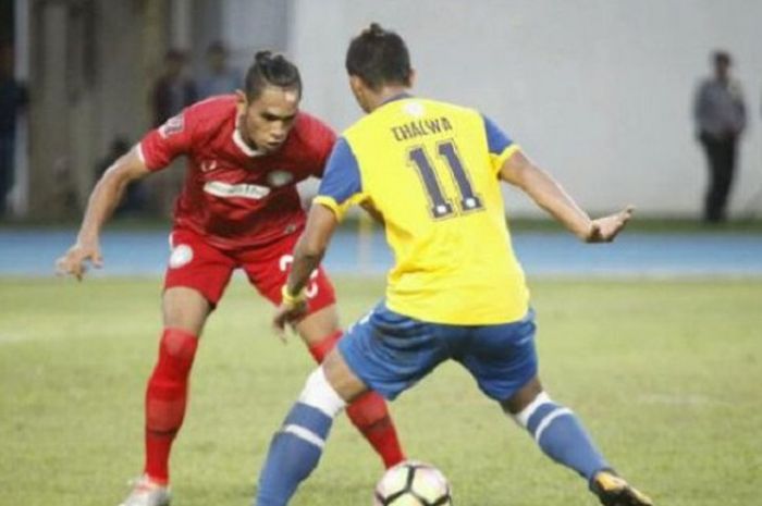 pemain belakang Martapura FC, M Taufan (merah) saat menghadapi striker Barito 