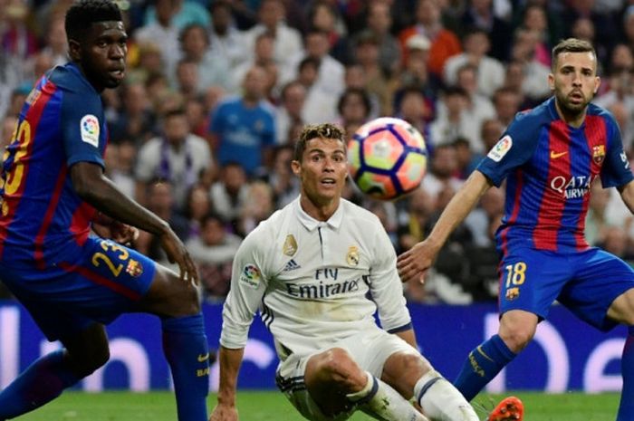 Bintang Real Madrid, Cristiano Ronaldo (tengah), diapit dua pemain Barcelona, Samuel Umtiti (kiri) dan Jordi Alba dalam partai Liga Spanyol di Santiago Bernabeu, Madrid, 23 April 2017.