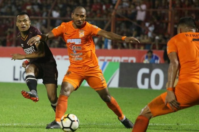 Penyerang PSM Makassar, Ferdinand Sinaga, melepas tembakan yang berusaha dihadang oleh pemain Borneo FC, Leonard Tupamahu, pada laga Liga 1 2018 di Stadion Andi Matalatta, Makassar, Sabtu (19/5/2018). 
