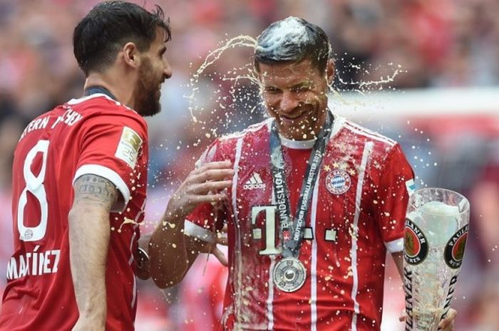 Gelandang Bayern Muenchen, Xabi Alonso (kanan), merayakan keberhasilan timnya menjuarai Liga Jerman 2016-2017 bersama Javi Martinez seusai pertandingan menghadapi Freiburg di Allianz Arena, Muenchen, Jerman, pada Sabtu (20/5/2017).