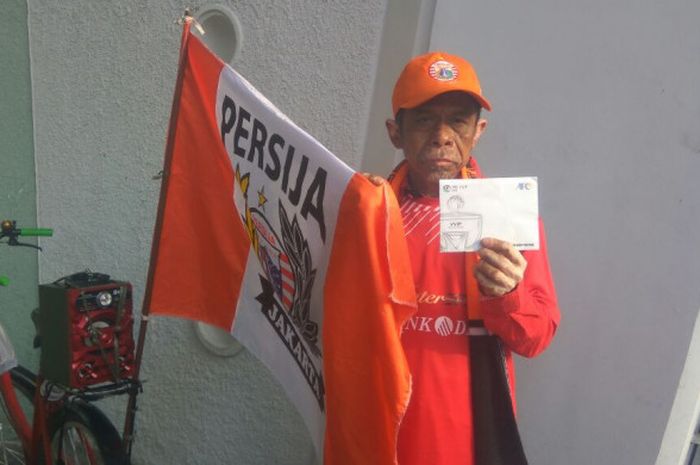 Penggemar setia Persija Jakarta, Suyatman (59) menunjukkan tiket VIP yang diberikan klub sebagai apresiasi terhadap loyalitasnya.