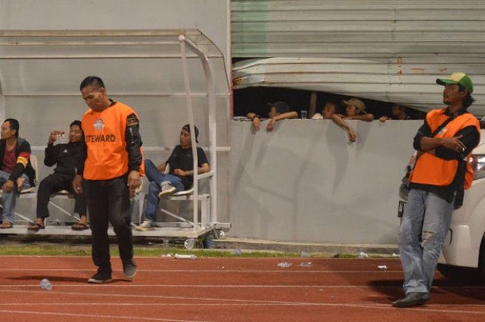 Oknum suporter PSIS Semarang memanfaatkan celah penutup tembok untuk menyaksikan laga kontra Persela Lamongan di Stadion Moch Soebroto, Senin (7/5/2018).