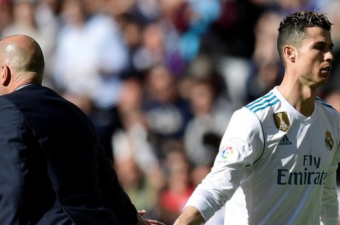 Pelatih Real Madrid, Zinedine Zidane (kiri), menyalam Cristiano Ronaldo yang ditarik keluar dalam laga Liga Spanyol kontra Atletico Madrid di Stadion Santiago Bernabeu, Madrid pada 8 April 2018.