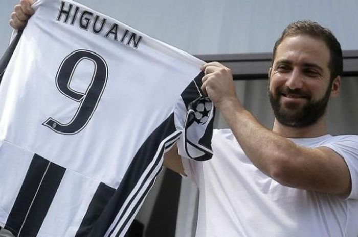 Striker anyar Juventus, Gonzalo Higuain, memamerkan kostumnya dengan nomor punggung 9 di kantor pusat Juventus pada Rabu (27/7)