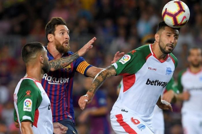 Lionel Messi mencoba menjangkau bola dari penjagaan Ruben Duarte dalam laga La Liga antara FC Barcelona kontra Alaves di Camp Nou, Barcelona, 18 Agustus 2018.